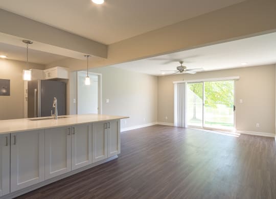 a kitchen and living room with a sliding glass door leading to a patio at Hillside Apartments, Michigan
