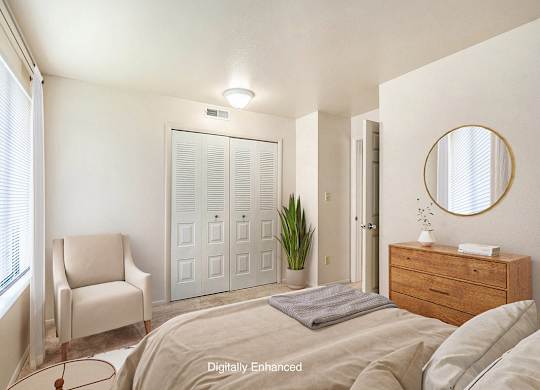 A bedroom with a bed, chair, a closet and a dresser at Irish Hills Apartments, South Bend, Indiana
