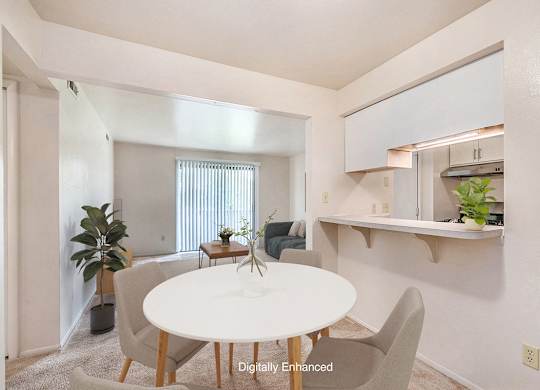 A dining room with a white table and chairs and a breakfast bar at Irish Hills Apartments, South Bend, Indiana