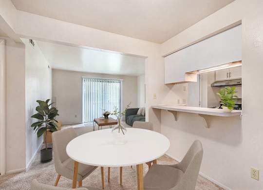 A dining room with a white table and chairs and a breakfast bar at Irish Hills Apartments, South Bend, Indiana