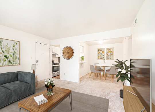 A living room with a couch and a dining room with a breakfast bar  and table with chairs at Irish Hills Apartments, South Bend, Indiana
