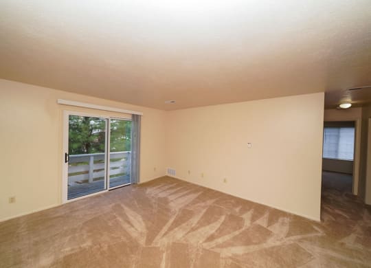 Living Room With Glass Door to Private Balcony at Irish Hills Apartments, South Bend, 46614