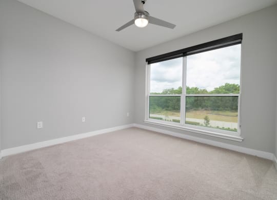 an empty room with a large window and a ceiling fan at Ironwood Flats in Brandon, 33511