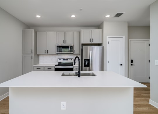 a white kitchen with a sink and a refrigerator at Ironwood Flats in Brandon, FL