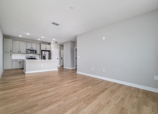 a living room and kitchen with wood floors and white walls at Ironwood Flats in FL 33511