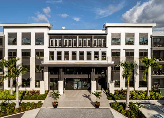 A modern building with a white facade and a central entrance at Ironwood Flats Apartments, Brandon