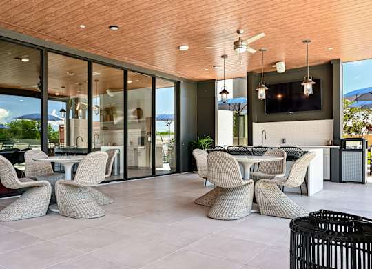 A modern outdoor dining area with a wooden ceiling and glass walls at Ironwood Flats Apartments, Brandon, 33511