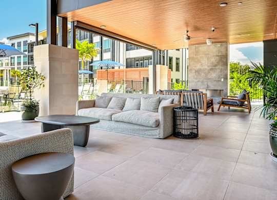 A modern outdoor seating area with a variety of furniture and plants. at Ironwood Flats Apartments, Brandon, FL