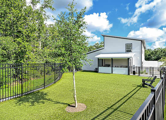 A white house with a black fence and a tree in the front yard at Ironwood Flats Apartments, Brandon, 33511