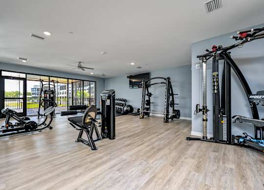 A spacious gym with a variety of equipment including a rowing machine, a stationary bike, and a treadmill at Ironwood Flats Apartments, Brandon, 33511