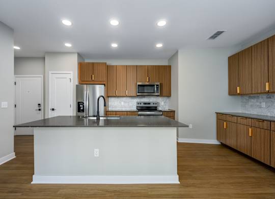 A kitchen with a black countertop and wooden cabinets.