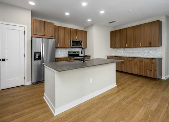 A kitchen with wooden cabinets and a white island.