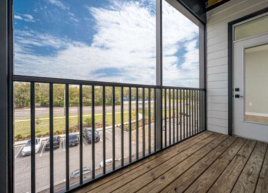 A balcony with a black railing and a white door.