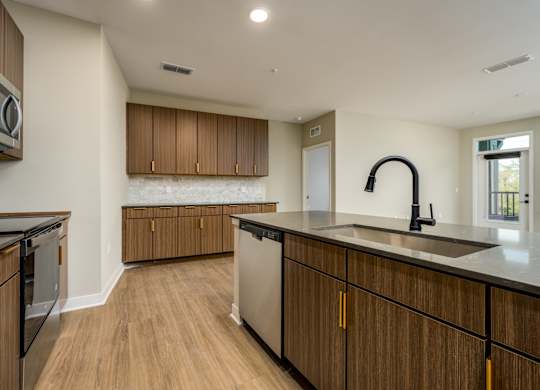 A kitchen with wooden cabinets and black countertops.