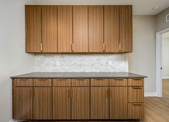 A kitchen with wooden cabinets and a marble countertop.