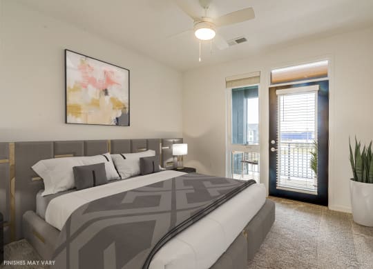 a bedroom with a large bed and a door leading to a balcony  at Uptown Square Apartments, Troy, Michigan