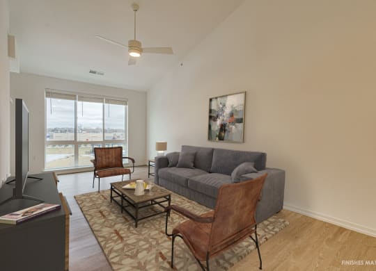 a living room with a gray couch and two brown chairs  at Uptown Square Apartments, Troy