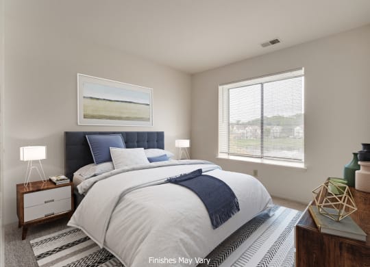 a bedroom with a bed and two windows at The Landings Apartments, Michigan