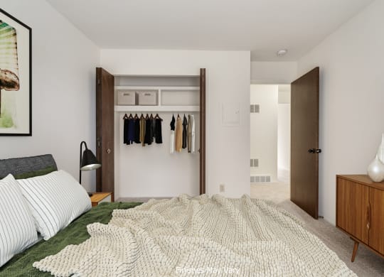 a bedroom with white walls and a large bed with a white blanket at The Landings Apartments, Westland, 48185