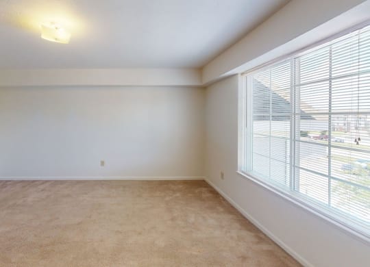 Spacious bedroom with a large window and plush carpet at Limestone Creek Apartment Homes, Alabama