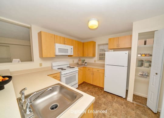 a kitchen with white appliances and wooden cabinets at Limestone Creek Apartment Homes, Madison, AL