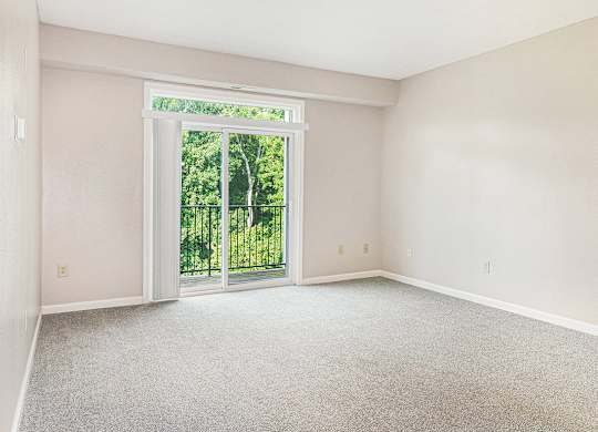 A living room with a carpeted floor and a 9 foot ceiling at Limestone Creek Apartment Homes, Madison, AL