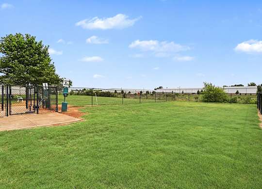 A pet park with a green lawn at Limestone Creek Apartment Homes, 35756