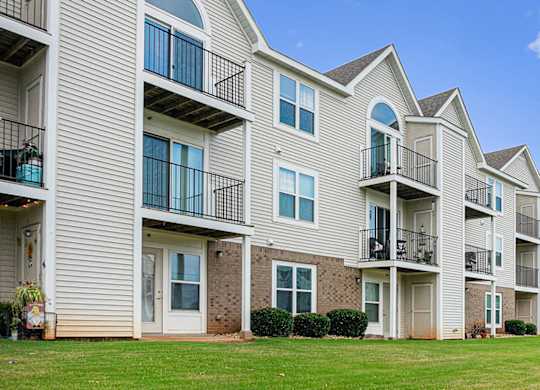 An exterior rear apartment building view of balconies and patios with private storage spaces at Limestone Creek Apartment Homes, Madison, AL