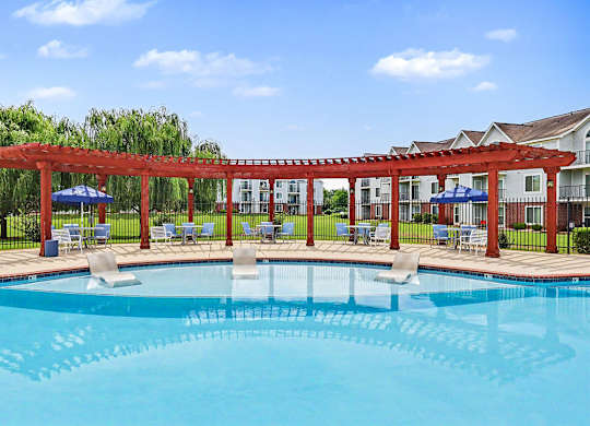 A pergola is over a pool with large sundeck at Limestone Creek Apartment Homes, 35756
