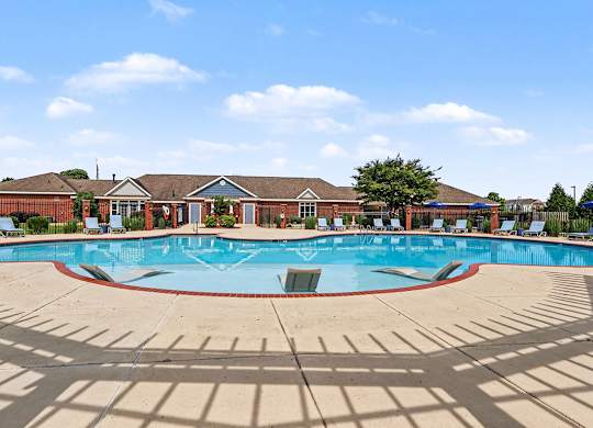 A large outdoor swimming pool with a building in the background at Limestone Creek Apartment Homes, 35756