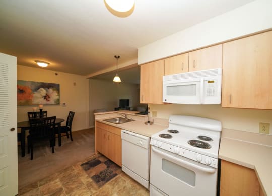 Maple Cabinetry and White Kitchen Appliances at Limestone Creek Apartment Homes, 35756
