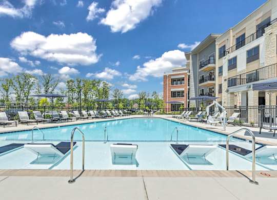 A large outdoor swimming pool with a metal ladder and a metal fence at Luxe 360 on Centerpointe Apartments, Midlothian, VA