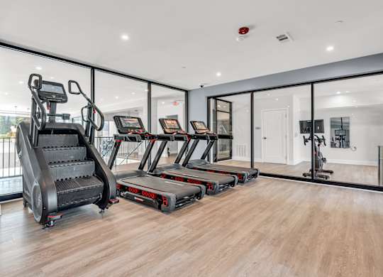 A gym with treadmills, elliptical machines, and a stair climber at Luxe 360 on Centerpointe Apartments, Midlothian