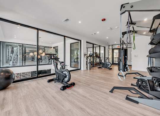 A gym with a variety of equipment including a stationary bike, a treadmill, and a rowing machine at Luxe 360 on Centerpointe Apartments, Midlothian
