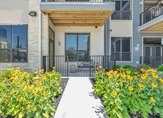 A building with a wooden entrance and a white walkway in front at Luxe 360 on Centerpointe Apartments, Midlothian, VA