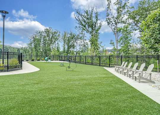 A park with a green lawn and a black fence
