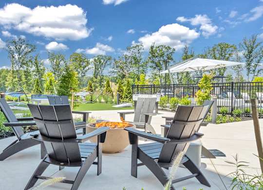 A patio with a table and chairs is set up for outdoor dining at Luxe 360 on Centerpointe Apartments, Midlothian, VA, 23114