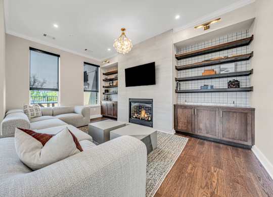A modern living room with a grey couch and a fireplace at Luxe 360 on Centerpointe Apartments, Midlothian, VA, 23114