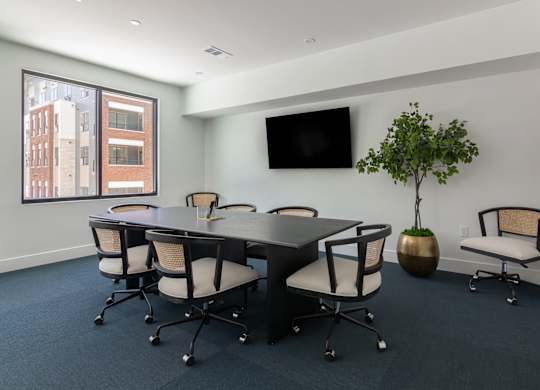 A conference room with a long table and chairs. at Luxe 360 on Centerpointe Apartments, Midlothian, VA