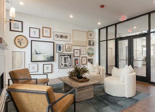 A living room with a brown chair and a plant on the coffee table at Luxe 360 on Centerpointe Apartments, Midlothian