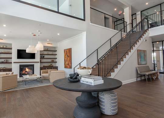 A living room with a fireplace and a staircase at Luxe 360 on Centerpointe Apartments, Midlothian, VA, 23114