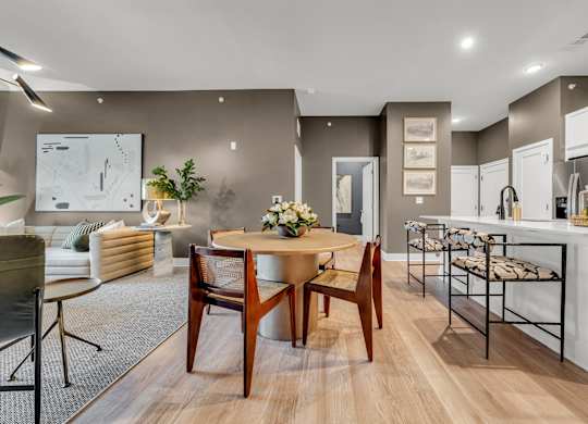 A modern dining room with a wooden table and chairs at Luxe 360 on Centerpointe Apartments, Virginia, 23114