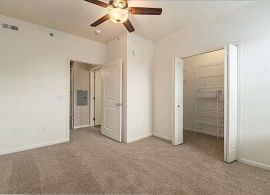 A bedroom with a ceiling fan and walk-in closet at Lynbrook Apartments and Townhomes, Elkhorn, NE, 68022