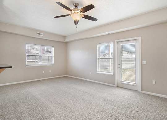 An end style living room with a ceiling fan and windows at Lynbrook Apartments and Townhomes, Elkhorn, NE, 68022
