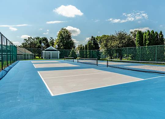 A tennis court with a blue surface and white lines at Mallard Bay Apartments, Crown Point, Indiana