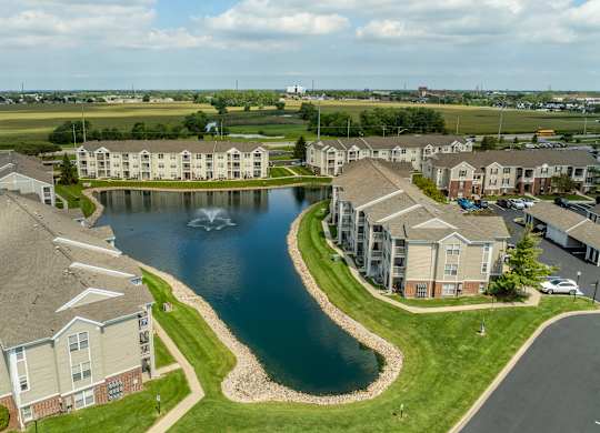A large building complex with a lake in the middle at Mallard Bay Apartments, Crown Point, Indiana