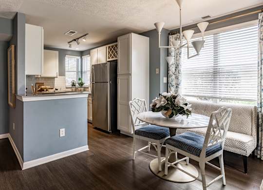A kitchen with a table and chairs in front of a window at Mallard Bay Apartments, Crown Point, Indiana