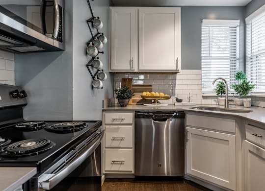 A modern kitchen with a stove, sink, and cabinets at Mallard Bay Apartments, Crown Point, Indiana