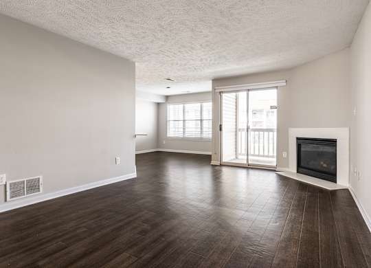 A spacious living room with wood flooring and a fireplace at Mallard Bay Apartments, Crown Point, Indiana