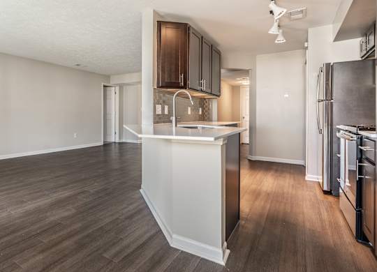 A kitchen with a refrigerator, sink, and cabinets at Mallard Bay Apartments, Crown Point, Indiana